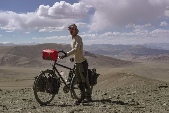 Marceau Lemoine à vélo, chargé, dans un paysage désertique